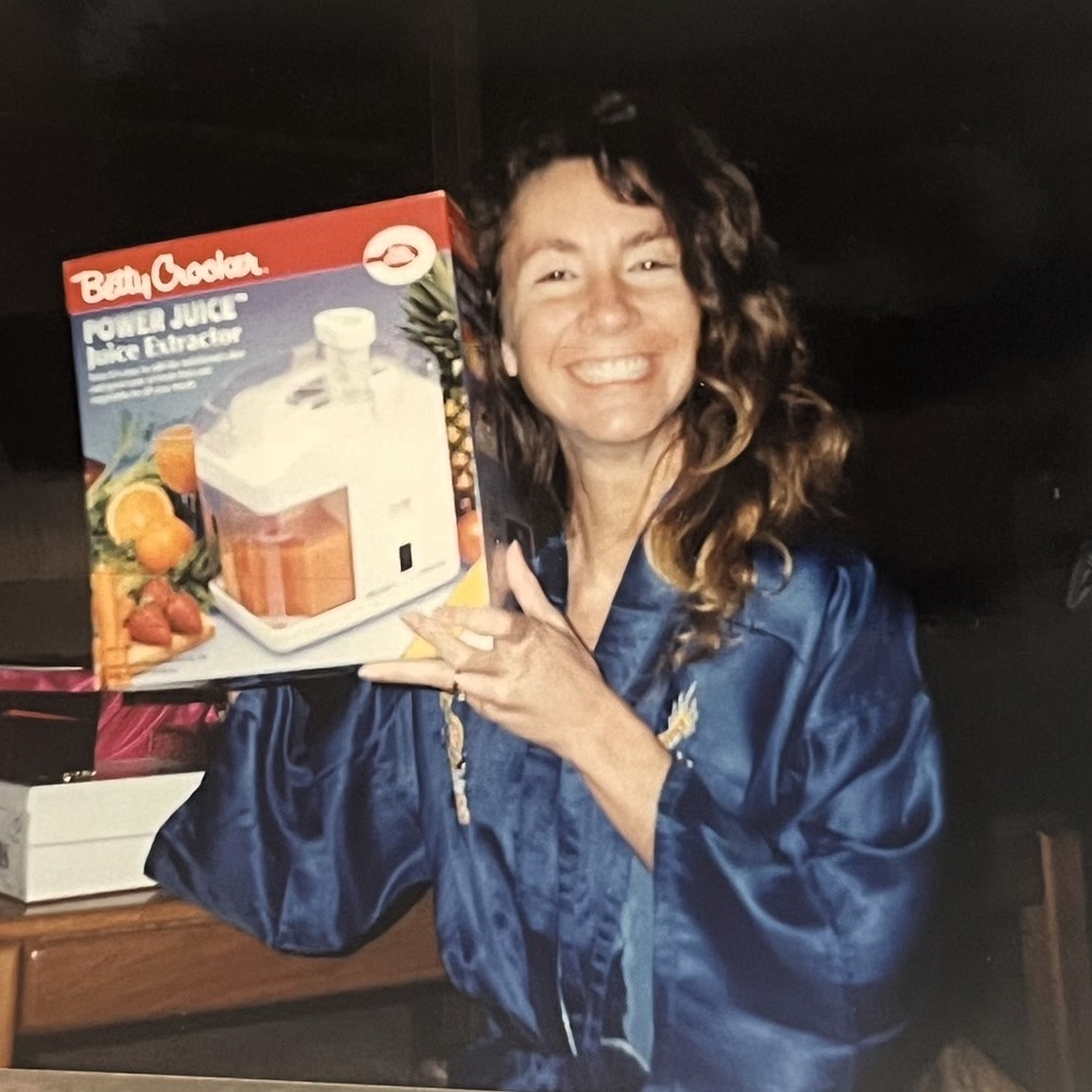 Young woman in the 1990s smiling and holding a juicer—early passion for healthy living