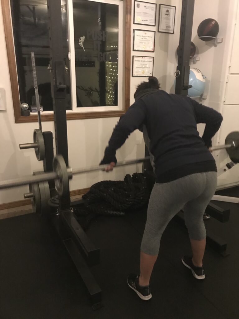 Midlife woman lifting weights in a personal training session